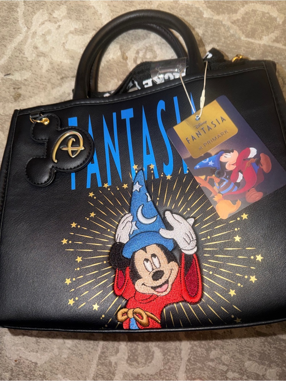 Disney Fantasia purse features Mickey Mouse embroidery and a "D" shaped zipper